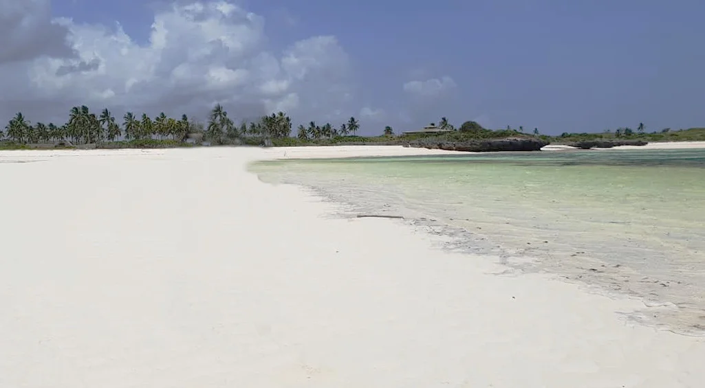 White sand, shallow tidal water and rocky coastal formations at Watamu Beach, Kenya